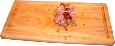 nadziewane  podudzie z kurczaka pomidorami suszonymi i pestkami dyni, drewniana deska do krojenia